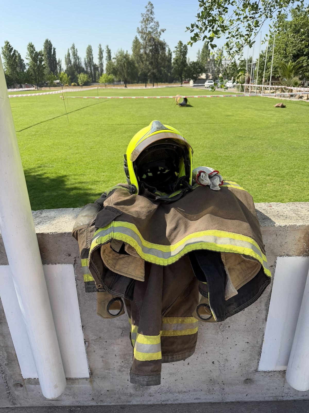 Casco y chaquetón de bombero junto al campo de entrenamiento en Chile
